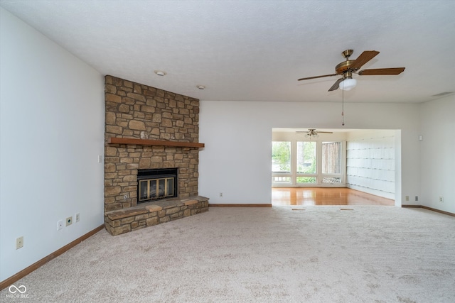 unfurnished living room featuring carpet flooring, a fireplace, a ceiling fan, baseboards, and visible vents