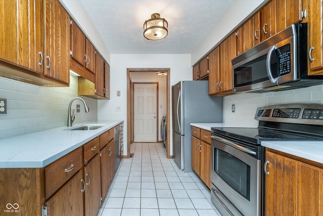 kitchen featuring a sink, appliances with stainless steel finishes, independent washer and dryer, and tasteful backsplash