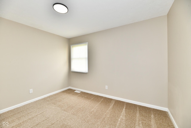 carpeted empty room featuring baseboards