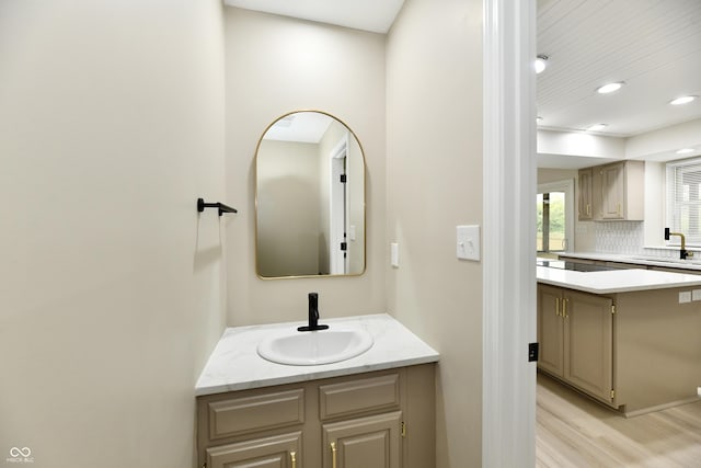 bathroom with vanity, backsplash, recessed lighting, and wood finished floors