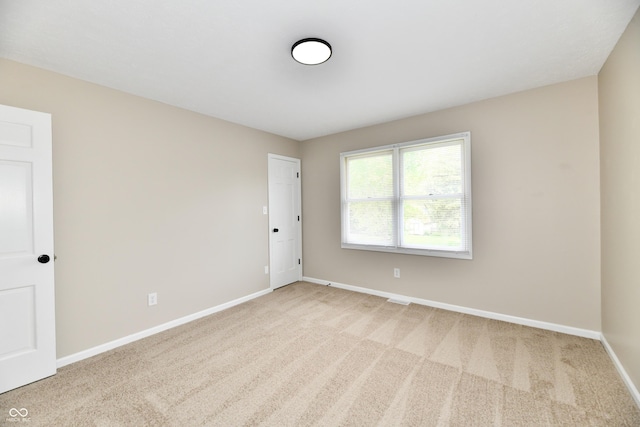empty room featuring carpet floors and baseboards