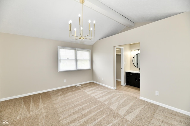 unfurnished bedroom featuring a walk in closet, light colored carpet, baseboards, lofted ceiling with beams, and an inviting chandelier
