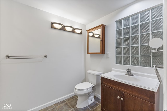 bathroom with vanity, baseboards, toilet, and tile patterned flooring