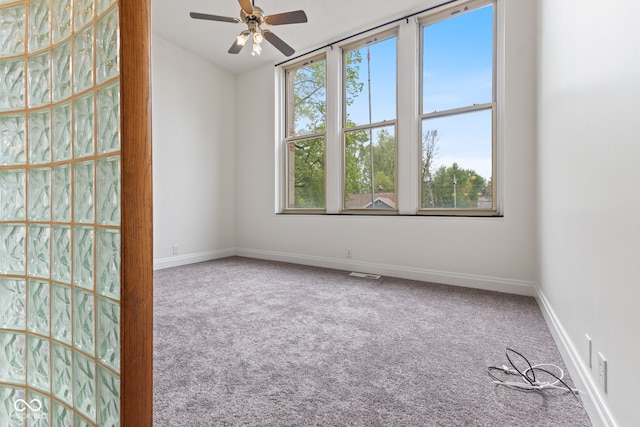 unfurnished room with carpet floors, a ceiling fan, baseboards, and visible vents