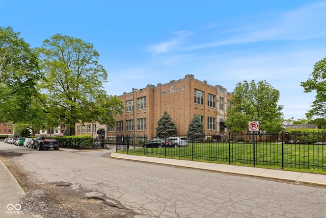 view of property with fence and uncovered parking