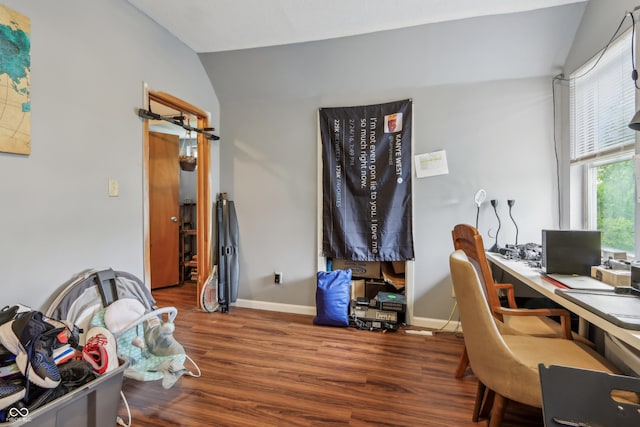 office area featuring lofted ceiling, baseboards, and wood finished floors