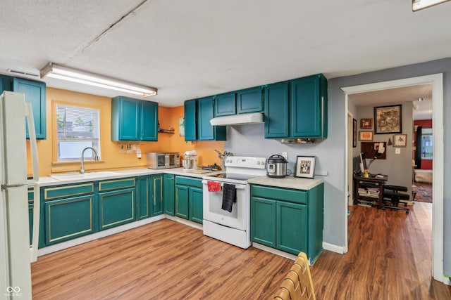 kitchen with light countertops, light wood-style floors, a sink, and white appliances