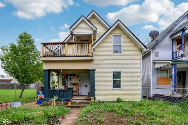 view of front of house featuring a porch, fence, and a balcony