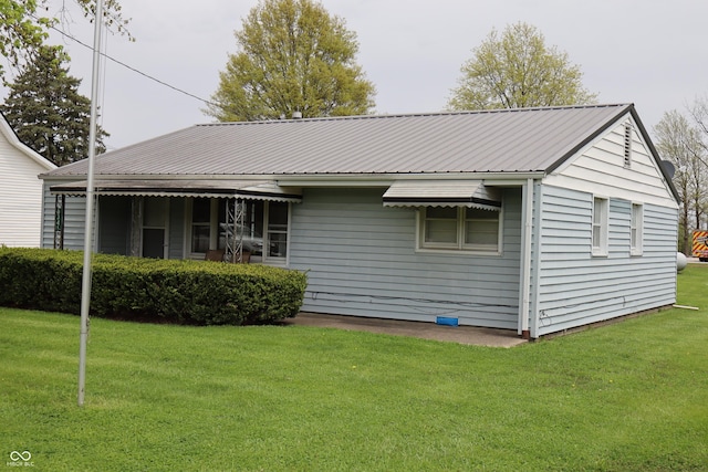 rear view of property with a yard and metal roof