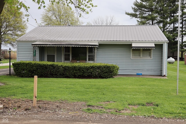 view of front of house featuring a front yard and metal roof