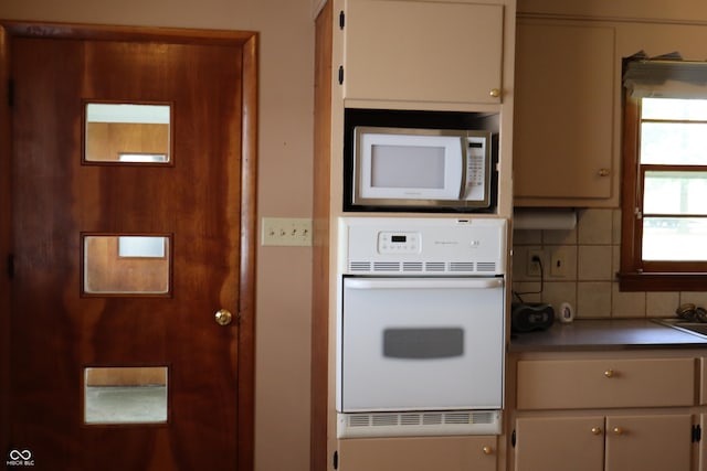 kitchen featuring white appliances and backsplash