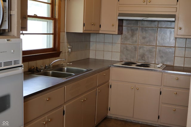 kitchen with a sink, tasteful backsplash, under cabinet range hood, and white appliances