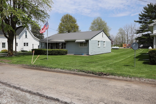 view of front facade featuring metal roof and a front lawn