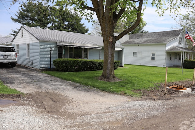 view of front of home featuring a front yard and metal roof