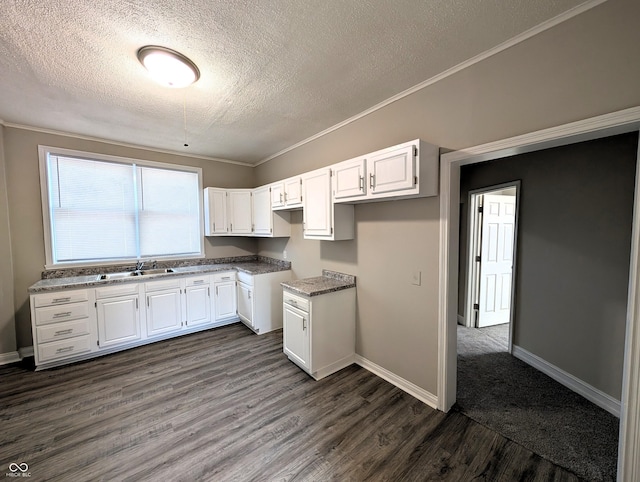kitchen featuring baseboards, a textured ceiling, dark wood finished floors, and white cabinets