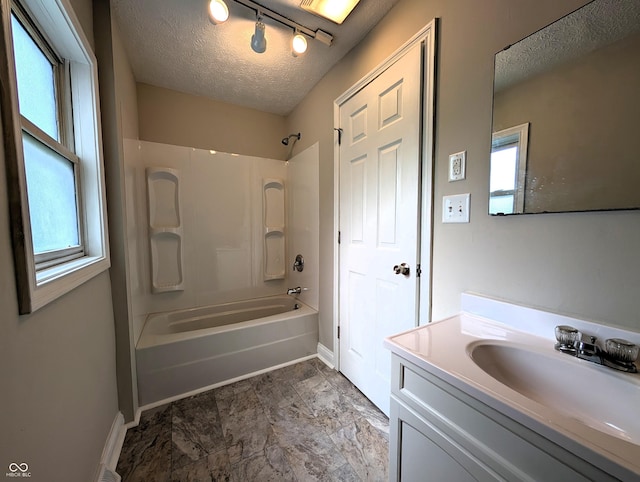 bathroom with baseboards, vanity, shower / bathtub combination, and a textured ceiling