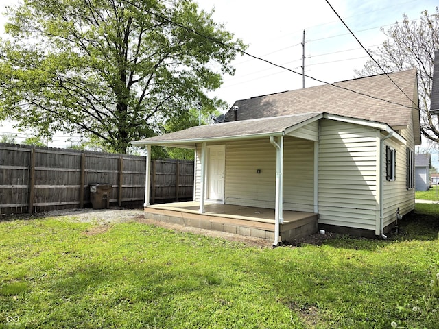 exterior space with a yard, fence, and roof with shingles