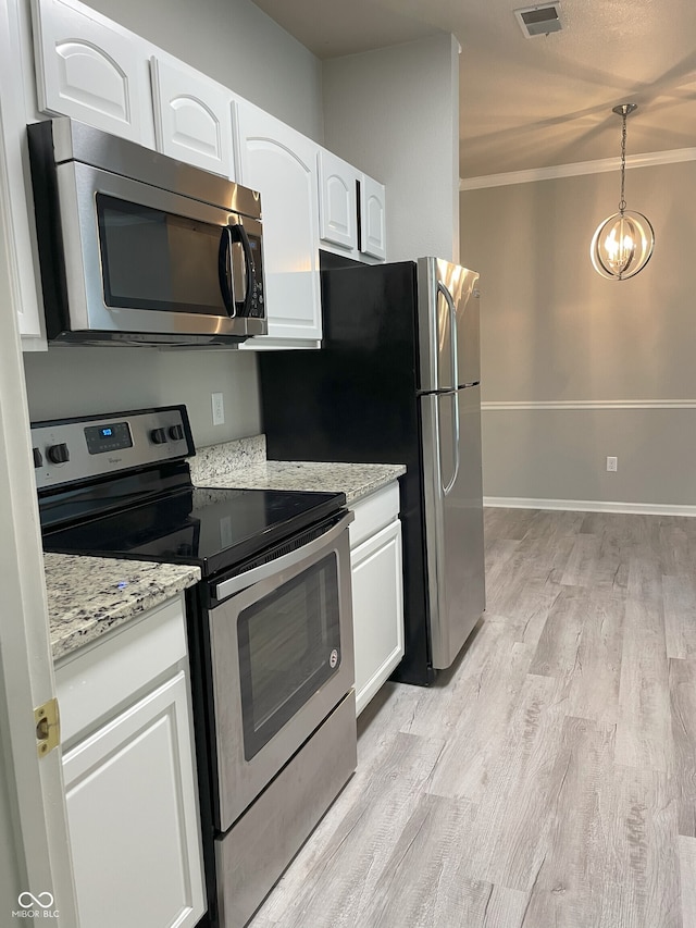 kitchen with stainless steel appliances, white cabinetry, light wood-type flooring, visible vents, and ornamental molding