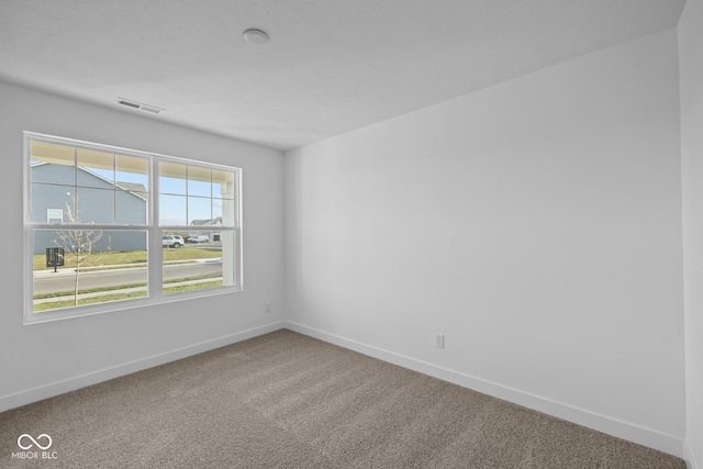 spare room with visible vents, baseboards, and carpet floors
