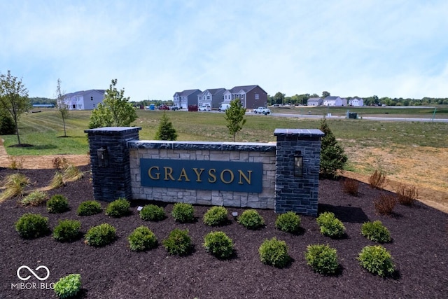 community / neighborhood sign with a lawn and a residential view
