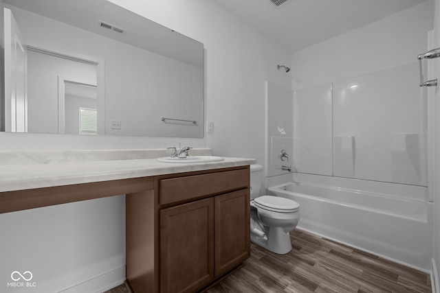 full bath with bathtub / shower combination, vanity, toilet, wood finished floors, and visible vents