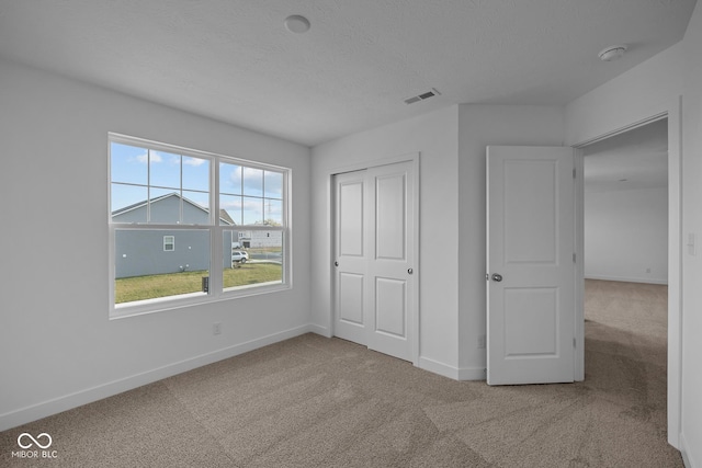 unfurnished bedroom with visible vents, carpet, and baseboards