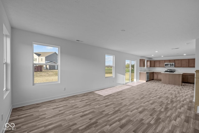 unfurnished living room with recessed lighting, baseboards, visible vents, and light wood-style flooring