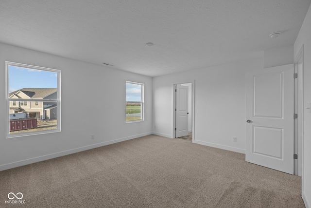 unfurnished room featuring carpet floors, baseboards, and visible vents