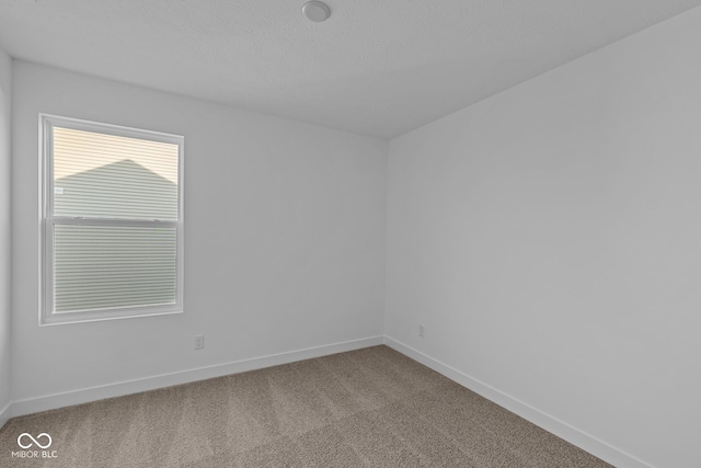 carpeted empty room with baseboards