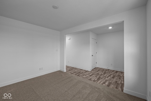 carpeted spare room featuring baseboards and recessed lighting