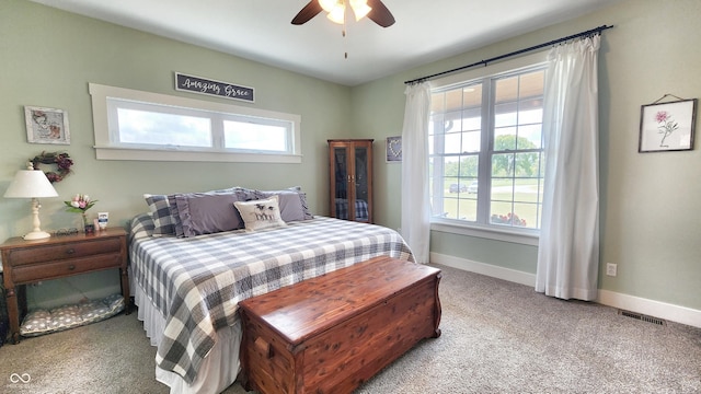 carpeted bedroom featuring baseboards, a ceiling fan, and visible vents