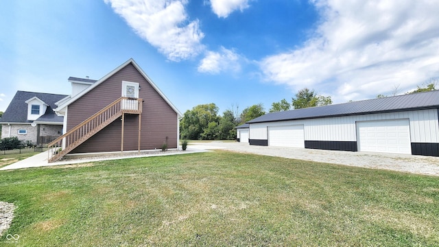 view of side of property featuring a yard, an outdoor structure, and a garage