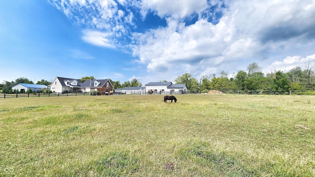 view of yard featuring fence, an enclosed area, and a rural view