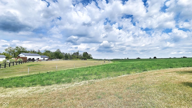 view of yard with a rural view and fence