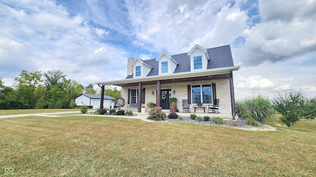 cape cod-style house featuring a porch, brick siding, and a front yard