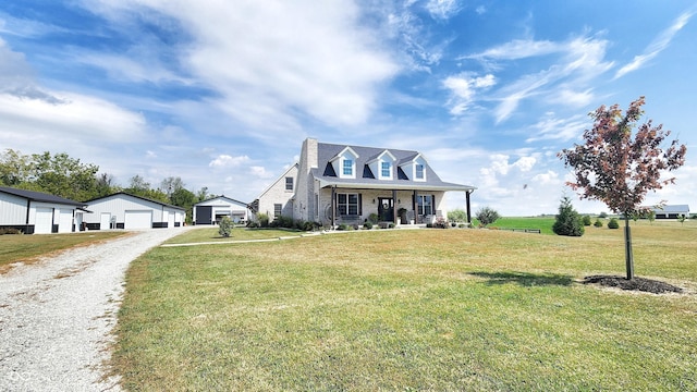 cape cod house featuring covered porch, a front lawn, and a detached garage