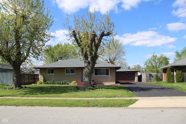 view of front of home with fence, a shingled roof, brick siding, and a front yard