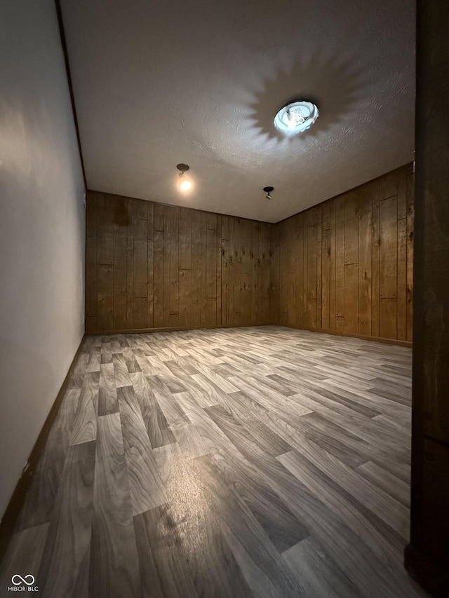 empty room with wooden walls and light wood-style flooring