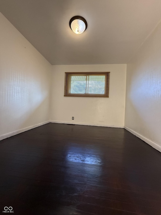unfurnished room featuring baseboards and wood finished floors