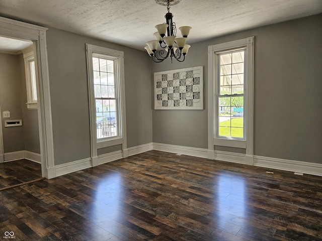 unfurnished dining area with an inviting chandelier, plenty of natural light, and hardwood / wood-style flooring