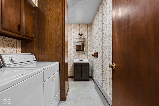 clothes washing area featuring independent washer and dryer, wallpapered walls, baseboard heating, and cabinet space