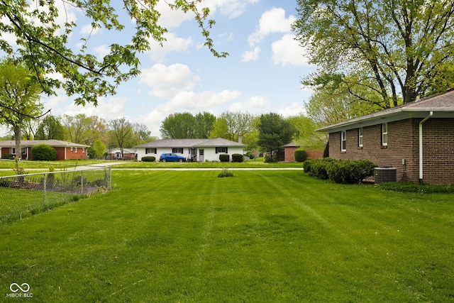 view of yard featuring fence and central AC unit