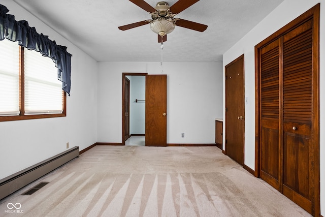 unfurnished bedroom featuring baseboards, a baseboard radiator, a ceiling fan, and carpet flooring