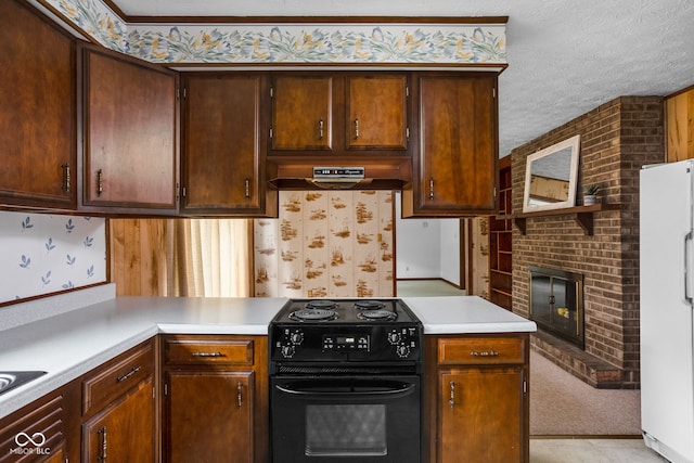 kitchen featuring a fireplace, light countertops, freestanding refrigerator, black range with electric cooktop, and under cabinet range hood