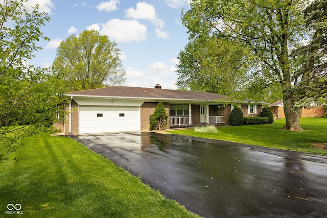ranch-style house featuring a porch, brick siding, aphalt driveway, and a garage