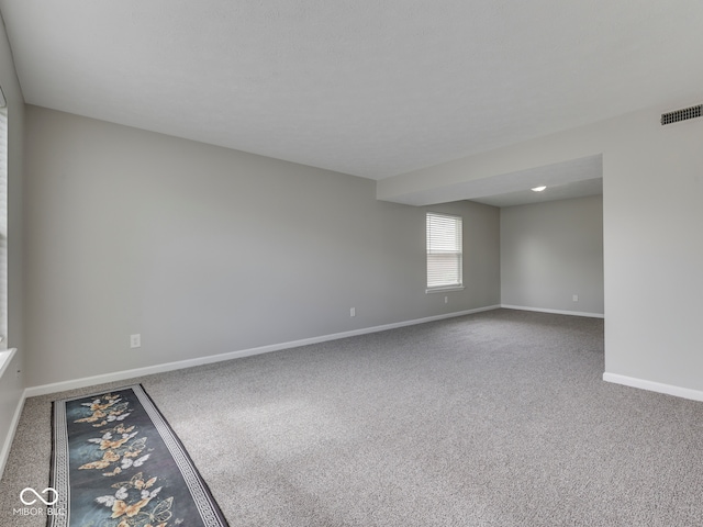 unfurnished room featuring carpet floors, baseboards, and visible vents