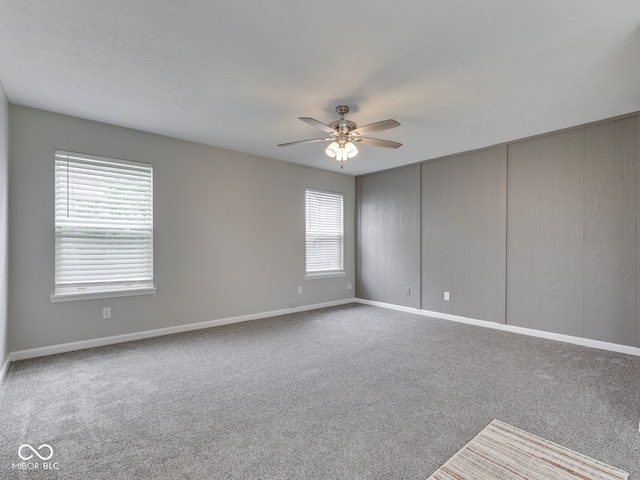 unfurnished room featuring a ceiling fan, baseboards, and carpet