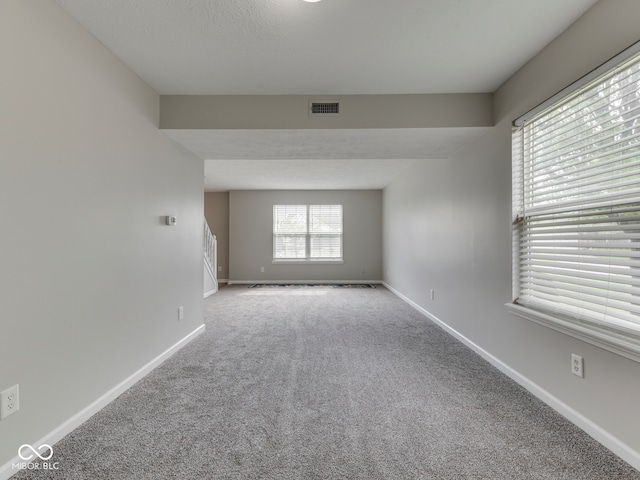 spare room with baseboards, carpet, and visible vents