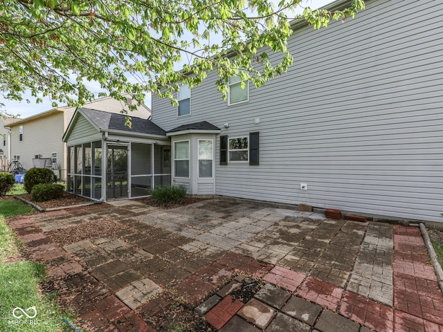 back of property with a patio and a sunroom