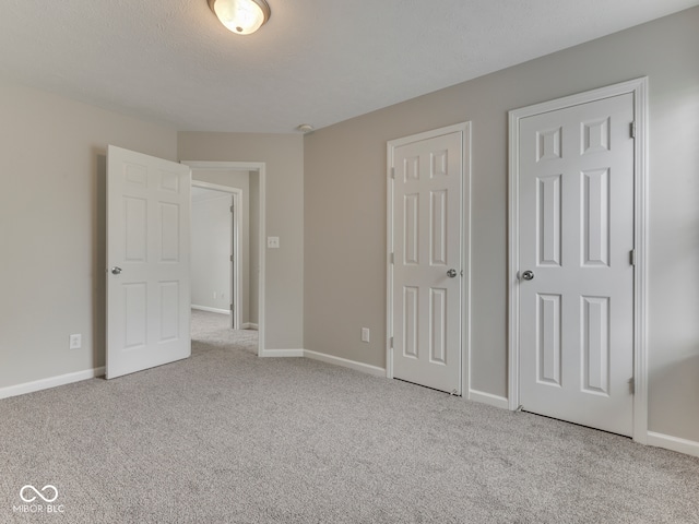unfurnished bedroom featuring baseboards and carpet